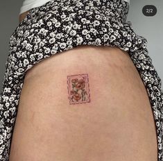 a woman's stomach with a small flower tattoo on the side of her belly