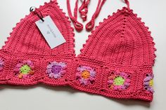 pink crocheted bralet with flowers on the front and side, attached to a string