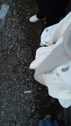 a person standing next to a pile of white bags on the ground with their feet propped up