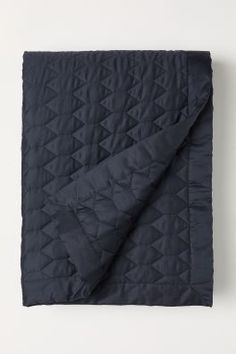 the dark blue quilted blanket is folded up