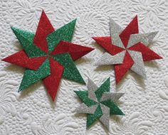 three red, green and silver paper stars on a white doily