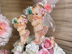 there are two baby dolls on top of flowers