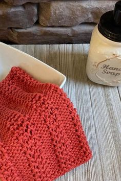 a red crocheted dish cloth next to a white bowl