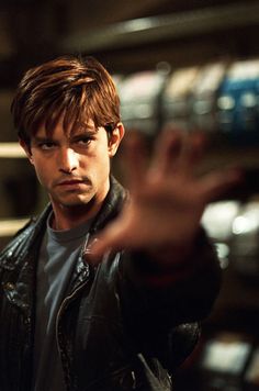 a man in a leather jacket holding his hand out