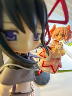 an anime figurine is posed in front of a computer screen