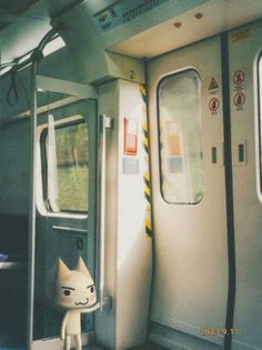 a cat doll sitting on the inside of a train