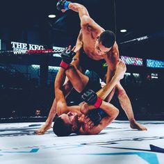 two men in the middle of wrestling with one holding on to another man's leg