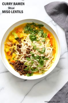 a bowl of curry ramen with miso lentils and garnishes