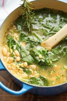 a blue pot filled with soup on top of a wooden table