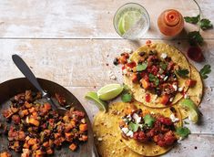 three tortillas with meat and vegetables on a wooden table