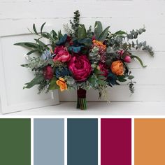 a bouquet of flowers sitting on top of a white table next to color swatches