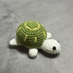 a small crocheted turtle sitting on top of a bed