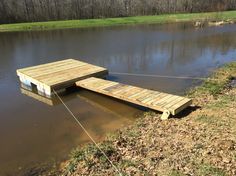 a wooden dock sitting in the middle of a flooded field next to a forest filled with trees