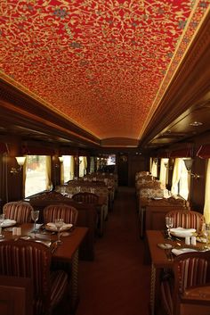 a dining car on a train with many tables and chairs set up in the middle