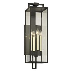 an outdoor wall light with four candles on the front and back panels, in black