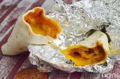 an open burrito sitting on top of aluminum foil