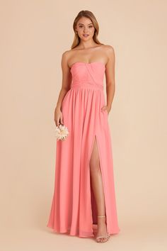 a woman in a strapless coral colored bridesmaid dress with high slits