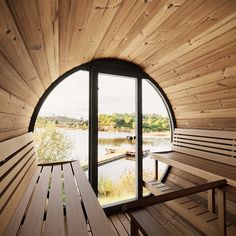 two wooden benches sitting next to each other near a window with a view of the water