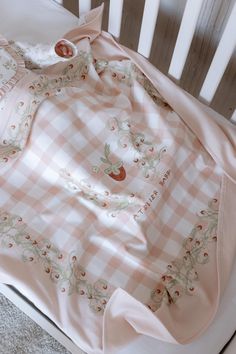 a pink and white blanket on top of a crib