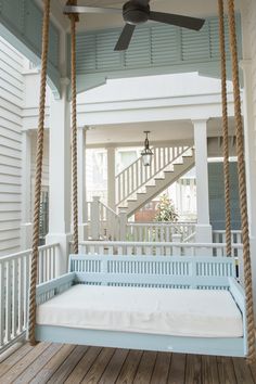 a porch swing with a ceiling fan on it