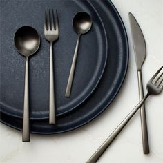 there are silverware on the plate with spoons and forks next to each other