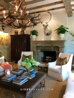 a living room filled with furniture and a fire place next to a wall mounted deer head