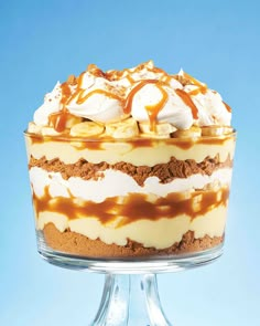 there is a cake with caramel sauce and whipped cream on top in a glass dish