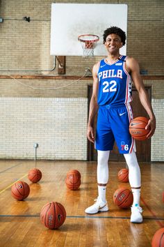 a young man standing on top of a basketball court holding a basketball in his hand