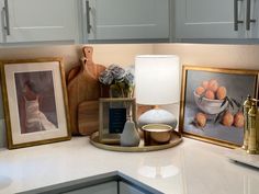 a kitchen counter with pictures and other items on top of it, including a lamp