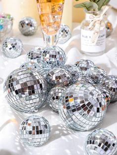 several disco balls sitting on top of a table next to a vase filled with flowers