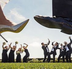 a group of people dressed in formal wear and high heels jumping up into the air