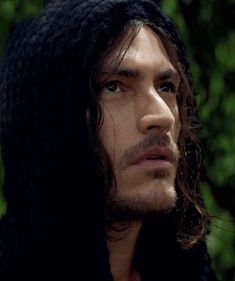 a close up of a person with long hair wearing a hoodie and looking off to the side