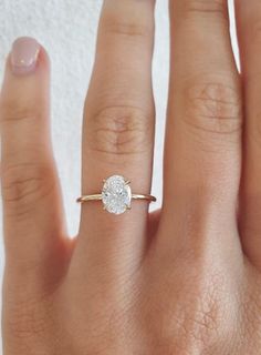 a woman's hand with a ring on it and a diamond in the middle