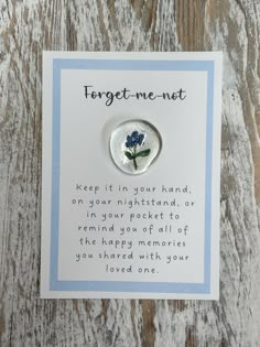 a white card with a blue flower on it that reads forget me not keep it in your hand