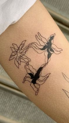 a woman's arm with tattoos on it and two birds in the middle of her arm