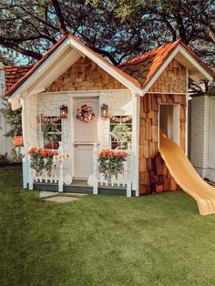 a small house with a slide in the yard