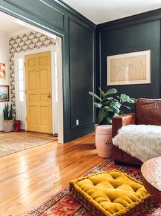 a living room filled with furniture and a rug on top of a hard wood floor