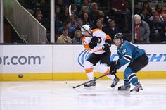 two hockey players playing on the ice in front of an arena full of people watching