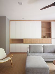 a living room filled with furniture and a ceiling fan in the middle of it's wall