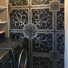 a washer and dryer are in front of an intricately designed wallpaper