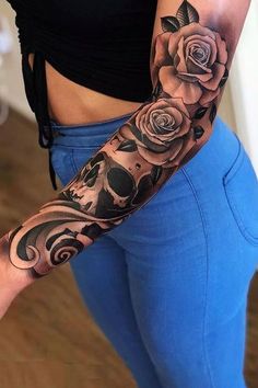 a woman's arm with roses and skulls on it