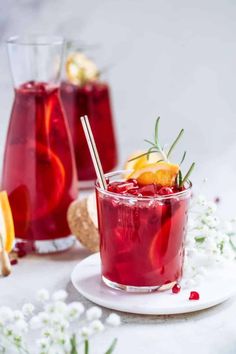 two glasses filled with red liquid and garnished with orange slices