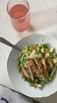 a white plate topped with salad next to a glass of water