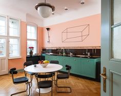 a kitchen with pink walls and green cabinets