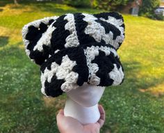 a black and white crocheted hat on top of a mannequin head