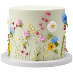 a white cake decorated with flowers and leaves