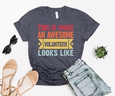 Awesome Volunteer Shirt, This Is What An Awesome Volunteer Looks Like T-Shirt, Volunteer Shirt, New Job Gift, Gift for Volunteer, Church Tee We want to make everyone smile with our cute, stylish and trendy graphic T-shirts. We can assure you this shirt will be perfect gift whether you will buy it yourself or for someone else. Made with top-of-the-line vinyl and pressed with a professional grade heat press. ATTENTION PLEASE   Black design for White, Yellow, Athletic Heather, Orange, Pink, Baby Blue, Mint, Natural , Desert Pink, Banana Cream, Cancun and Heather Peach. White design for all other colors. Premium Quality Printed in the USA. ---Production and Shipping--- Processing is 1-3 days.  No returns or exchanges since we custom create each shirt to your specifications. But please contact Volunteer Shirts Design, Volunteer Shirt, Desert Pink, Volunteer Gifts, Pink Banana, New Job Gift, Tshirt Ideas, Banana Cream, Pink Baby