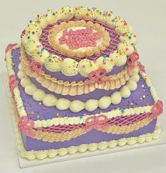 a three tiered cake is decorated with icing and sprinkles