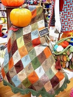 there are many knitted pumpkins on display in this market stall, including one for sale and the other for sale