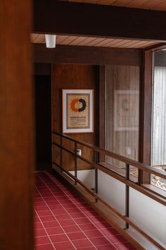 an empty room with red tile flooring and wood paneling on the walls is shown